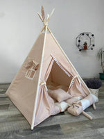 Tenda teepee bambini rosa antico con pompon bianchi cuscini e piume decorative
