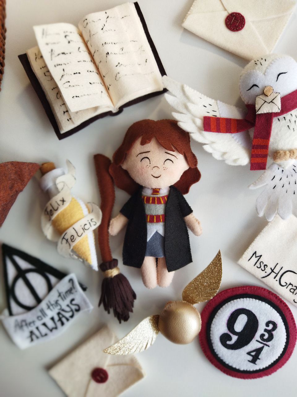 Dettaglio elementi in feltro per giostrina culla Harry Potter con Hermione Granger, boccino d'oro e libro degli incantesimi