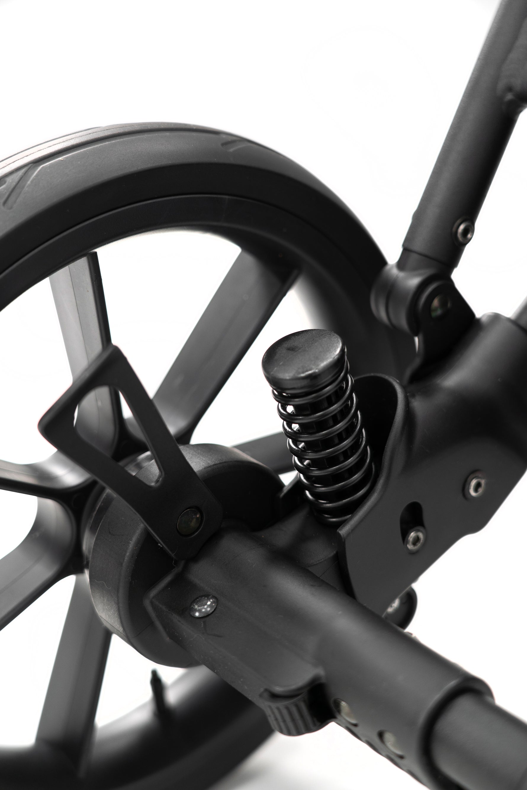 Dettaglio della molla di ammortizzazione posteriore del passeggino Kunert con ruota nera a raggiera per terreni difficili.
