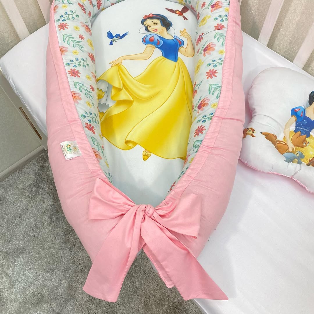 Baby nest neonata Biancaneve con bordi rosa e interno a fiori colorati, riduttore lettino personalizzato con fiocco.
