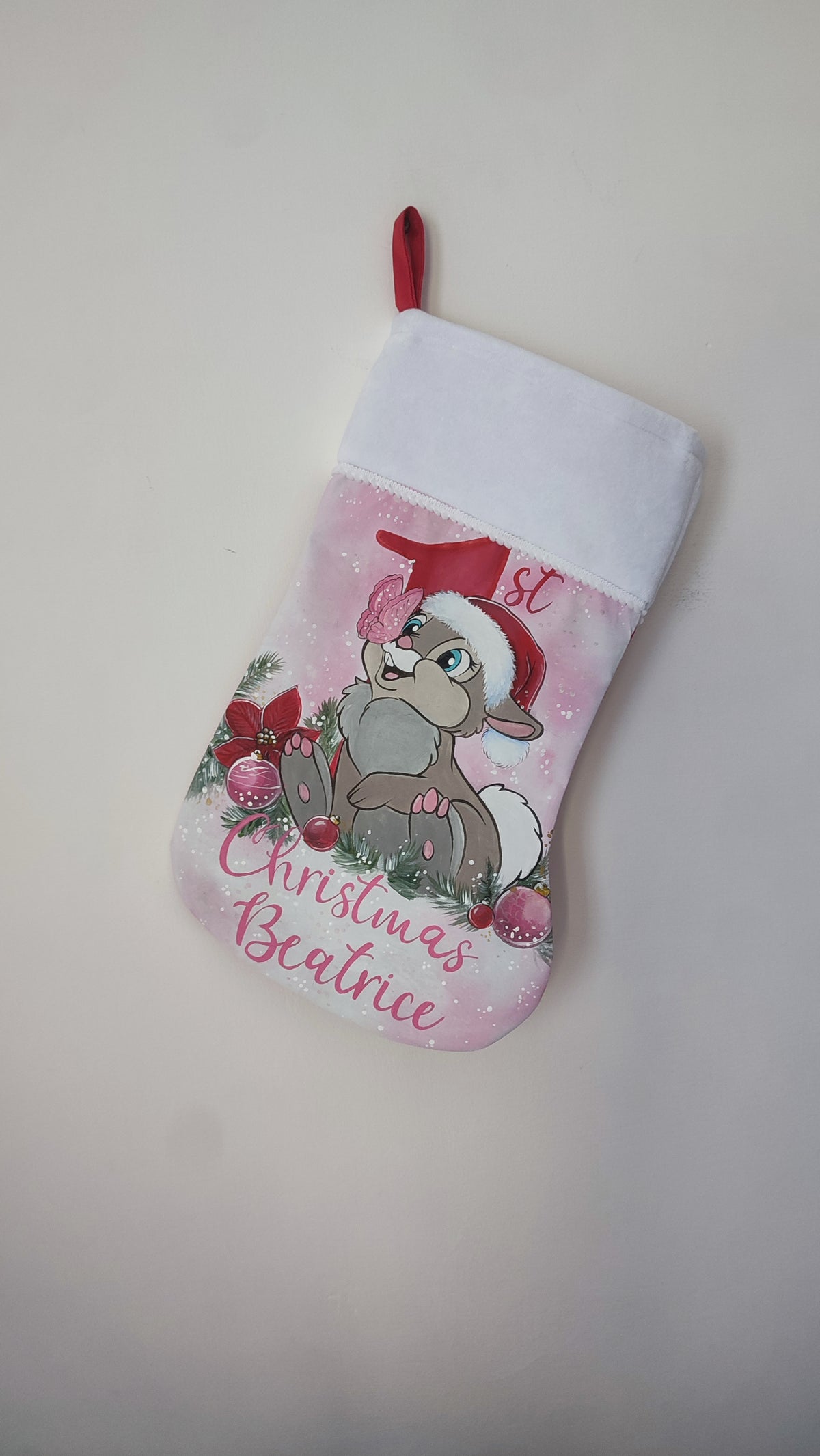 Calza di Natale rosa dipinta a mano per il primo Natale con illustrazione del coniglietto Tamburino e una farfalla.