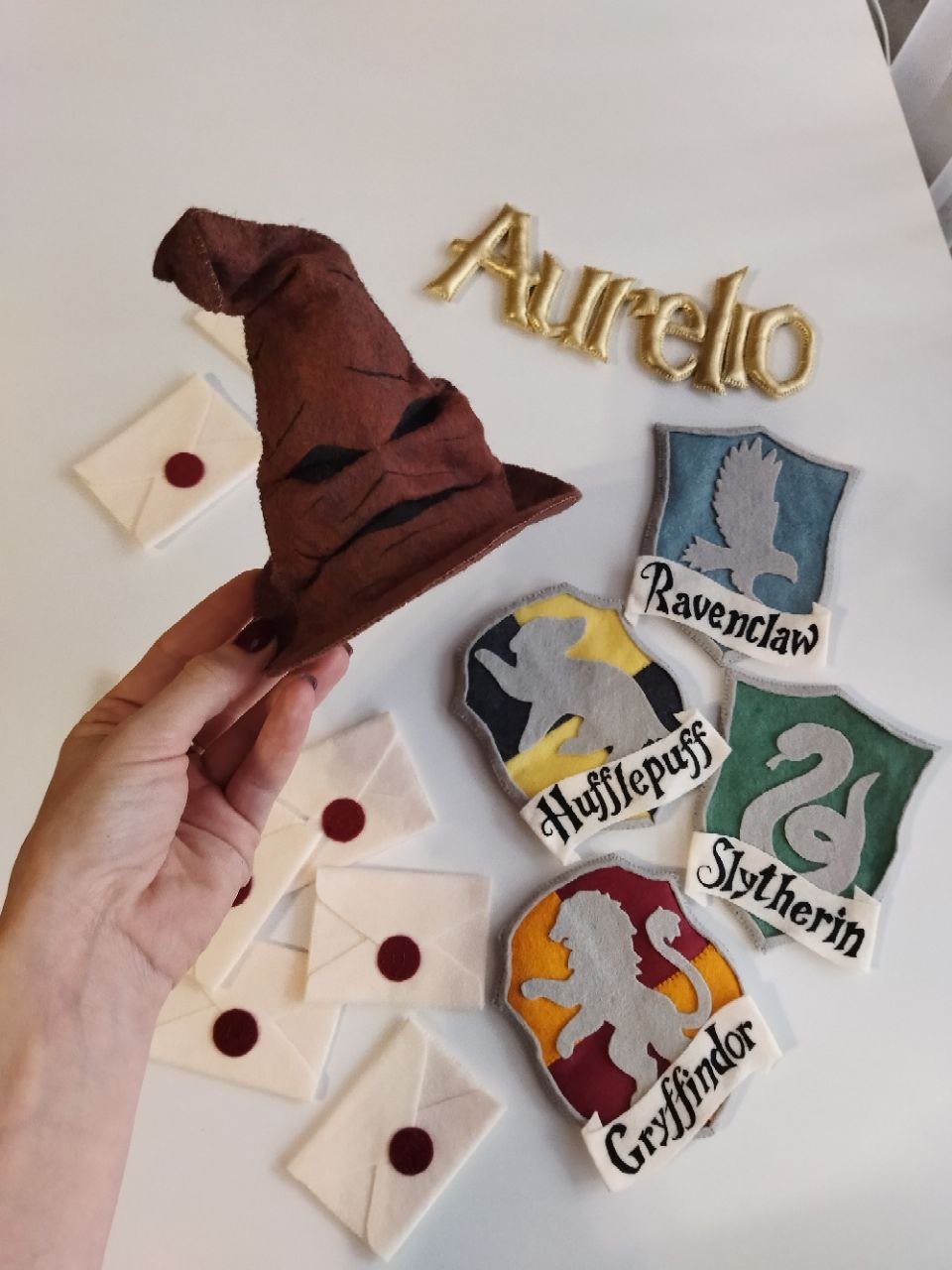  Giostrina culla Harry Potter dettaglio cappello parlante 3D in feltro fatto a mano e stemmi quattro case di Hogwarts.