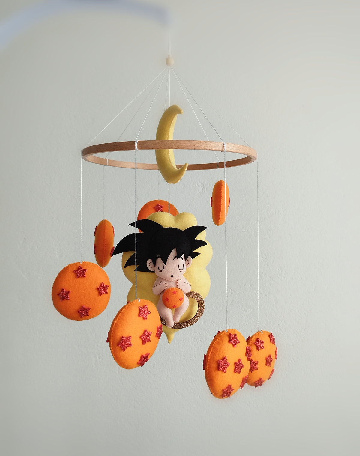 Carillon mobile neonati a tema anime con piccolo Goku dai capelli neri, luna gialla e sfere arancioni per lettino culla