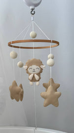 Carillon neonato mobile culla agnello feltro beige e panna stelle pendenti su culla bianca cameretta