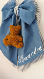 Dettaglio fiocco nascita azzurro jeans con orsetto bouclè color miele e nome ricamato in bianco