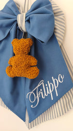 Coccarda nascita azzurro blu con bordo righe grigie, orsetto peluche color miele e scritta nome