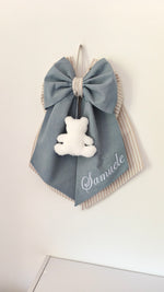 Coccarda nascita azzurro grigio con righe panna, orsetto peluche bianco e scritta nome ricamata