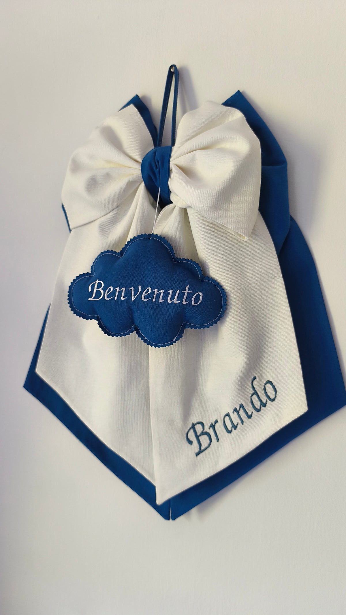 Coccarda nascita panna con bordo blu, nome bimbo ricamato e nuvoletta decorativa