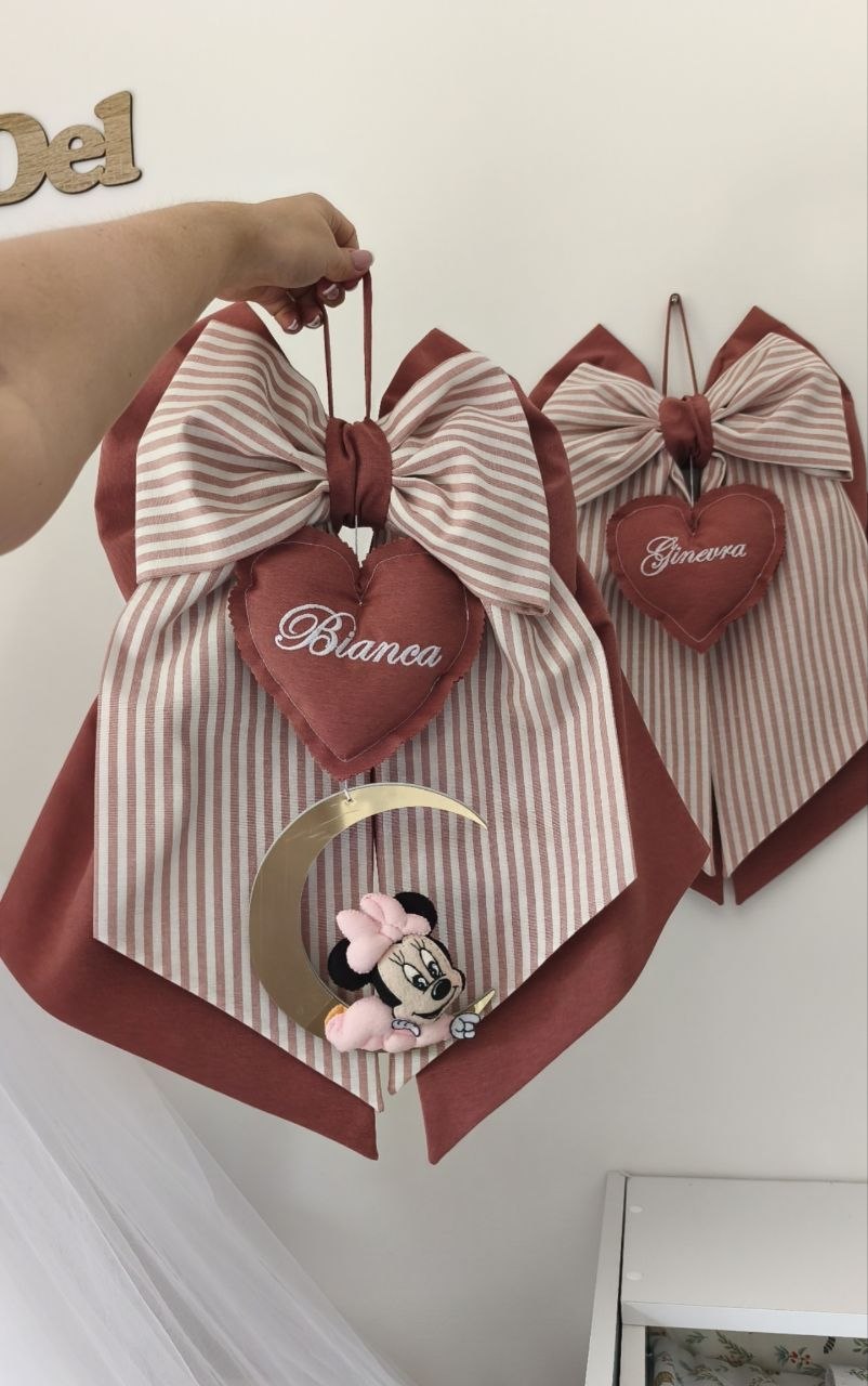 Coppia di fiocchi nascita rosso mattone e righe con cuori ricamati, luna dorata e pendente Minnie baby.