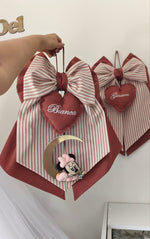 Coppia di fiocchi nascita rosso mattone e righe con cuori ricamati, luna dorata e pendente Minnie baby.