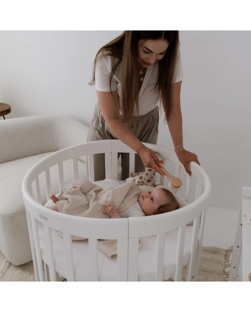 Lettino ovale neonato bianco con mamma che cura il bambino – culla rotonda in legno 
