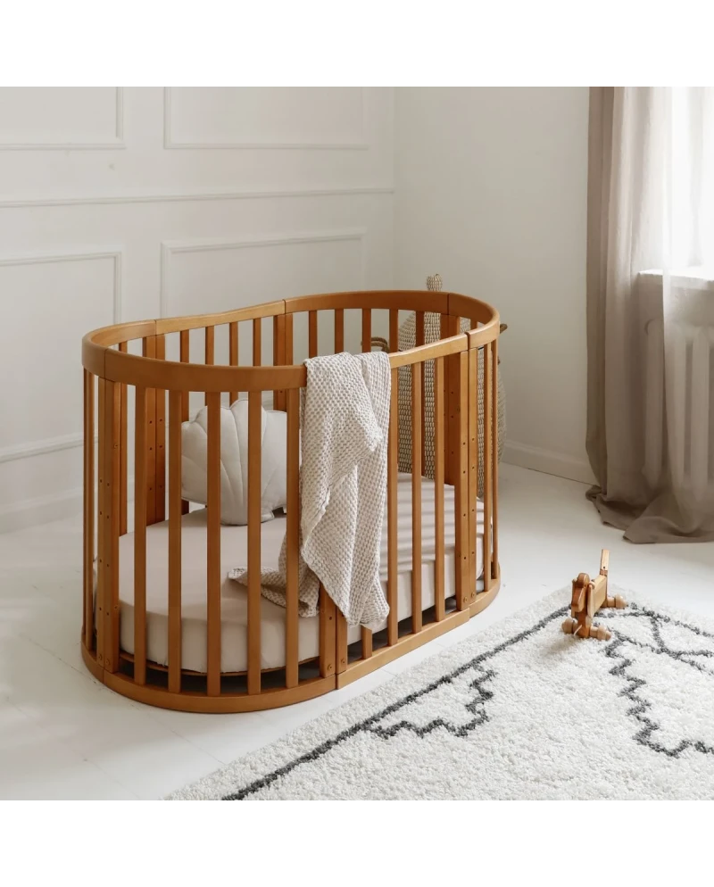 Culla ovale legno miele 7in1 con coperta e cuscino in cameretta minimal scandinava