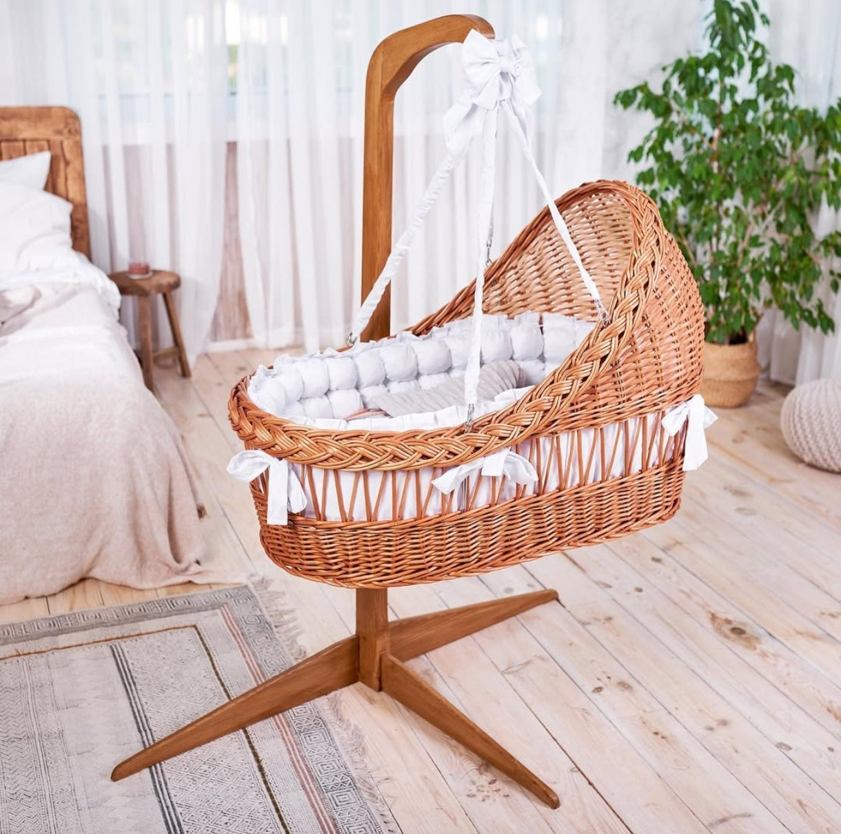Culla vimini colore miele intrecciata a mano con cappuccio, tessuto bianco, su piedistallo