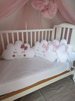 Cuscini decorativi a forma di nuvola bianchi e rosa antico con viso ricamato e fiocchetti per lettino neonata