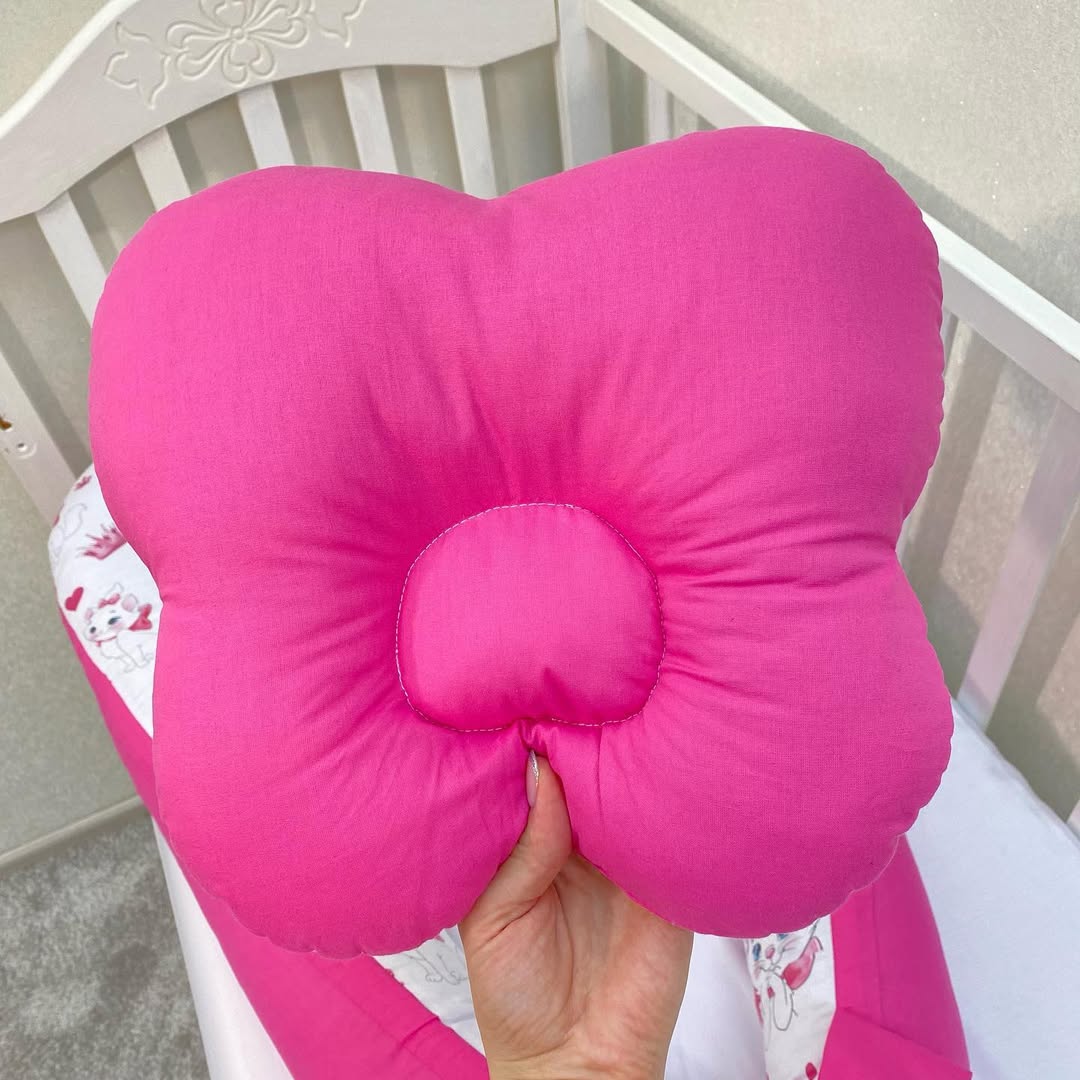 Retro cuscino anti plagiocefalia fucsia a farfalla, supporto ergonomico per testa piatta neonato.