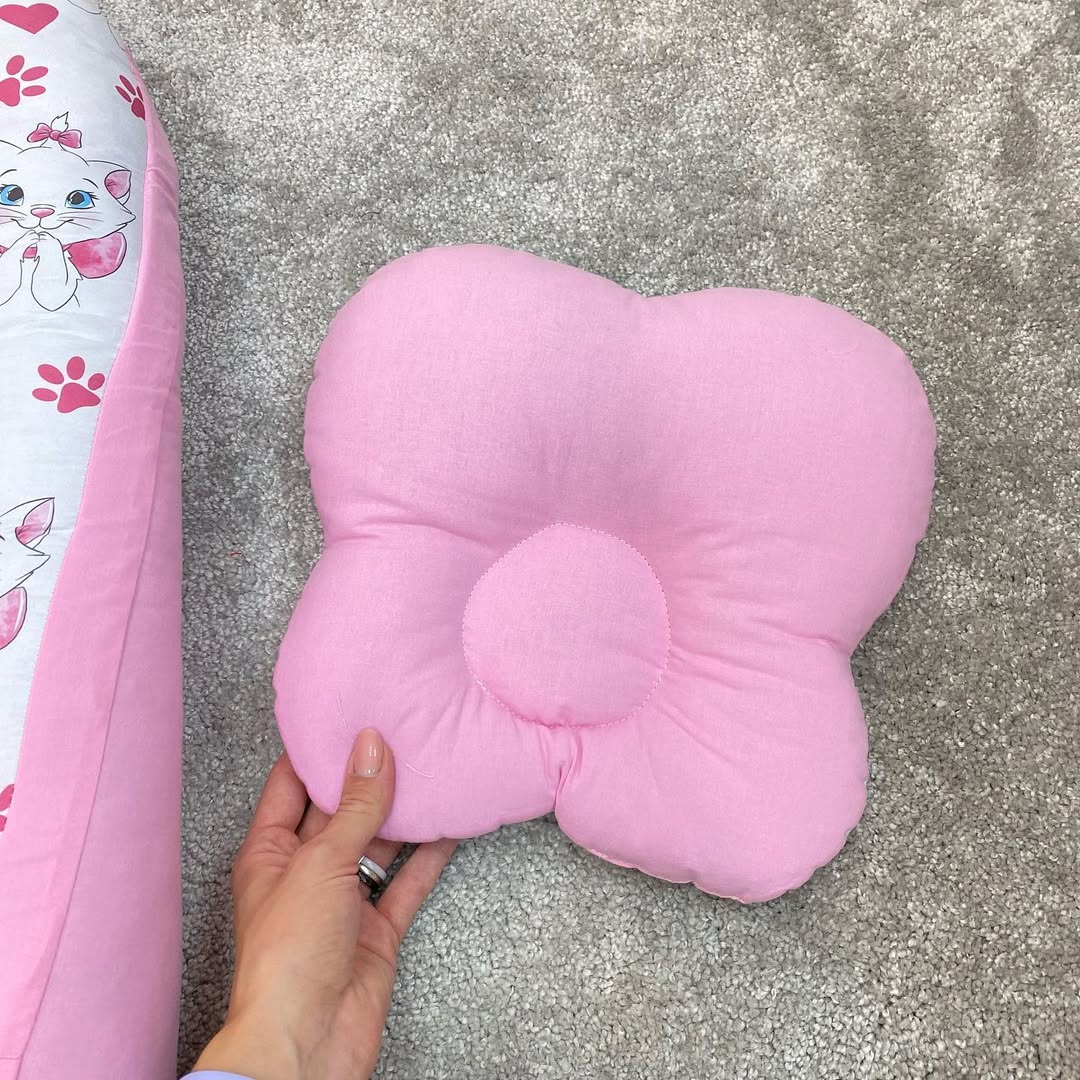 Retro cuscino anti plagiocefalia neonato rosa a forma di fiocco, supporto anatomico con foro centrale per testa piatta.