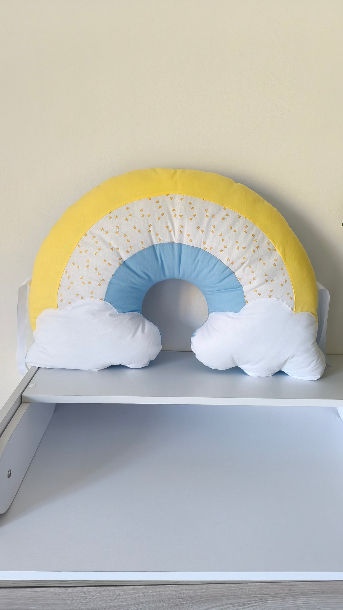 Cuscino paracolpi a forma di arcobaleno giallo e azzurro con stelline e nuvolette bianche per lettino e culla neonato.