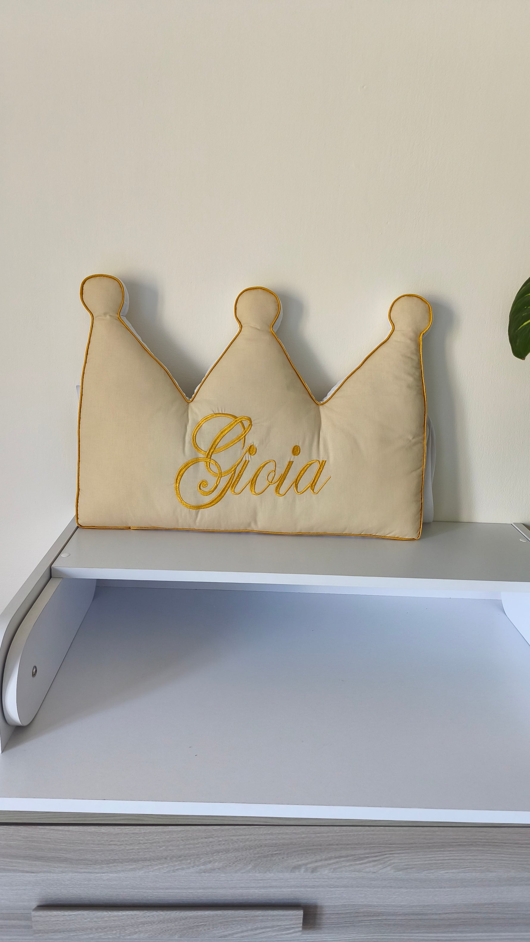 Cuscino paracolpi a forma di corona beige con nome Gioia ricamato in oro, ideale per lettino e culla neonata elegante.