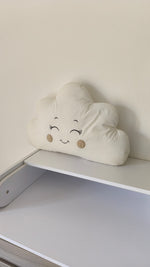 Cuscino paracolpi a forma di nuvoletta color panna con occhi ricamati e guance beige, ideale per una culla neutra.