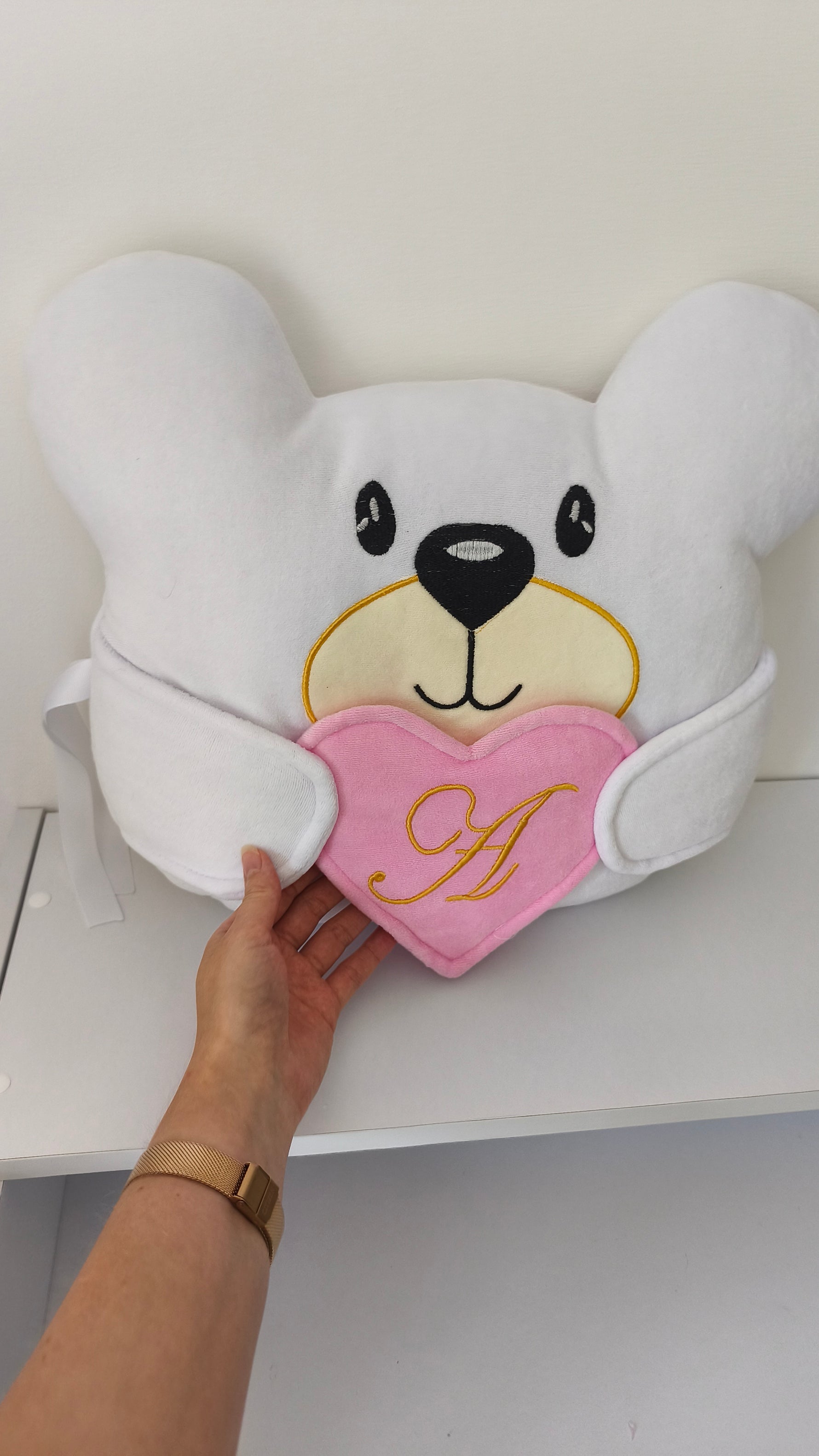 Cuscino paracolpi a orsetto bianco con cuore rosa ricamato con iniziale in oro, ideale per lettino neonata personalizzato.