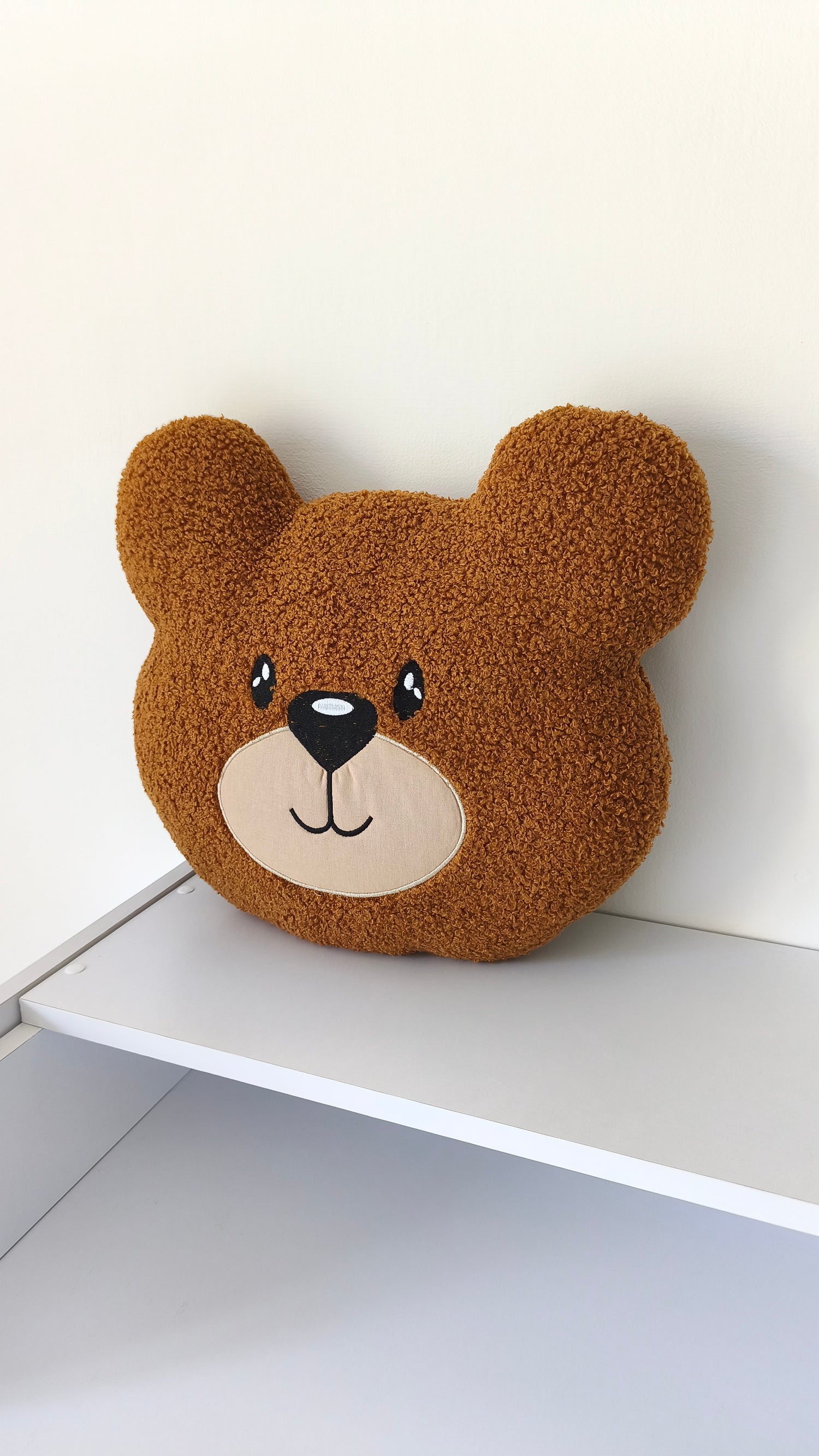 Cuscino paracolpi a forma di orsetto marrone in tessuto riccio bouclé, morbido accessorio d'arredo per lettino neonato.