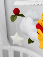 Giostrina musicale Winnie the Pooh e nuvole in feltro, dettaglio decorazioni fatte a mano per cameretta neonati.