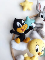 Dettaglio di Daffy Duck in feltro su nuvole bianche, particolare di una giostrina per culla a tema Baby Looney Tunes