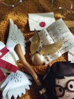 Giostrina musicale lettino dettaglio boccino d'oro glitter e lettera di Hogwarts in feltro