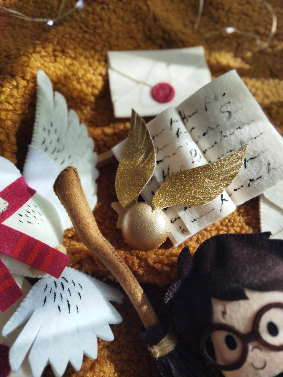 Giostrina musicale lettino dettaglio boccino d'oro glitter e lettera di Hogwarts in feltro