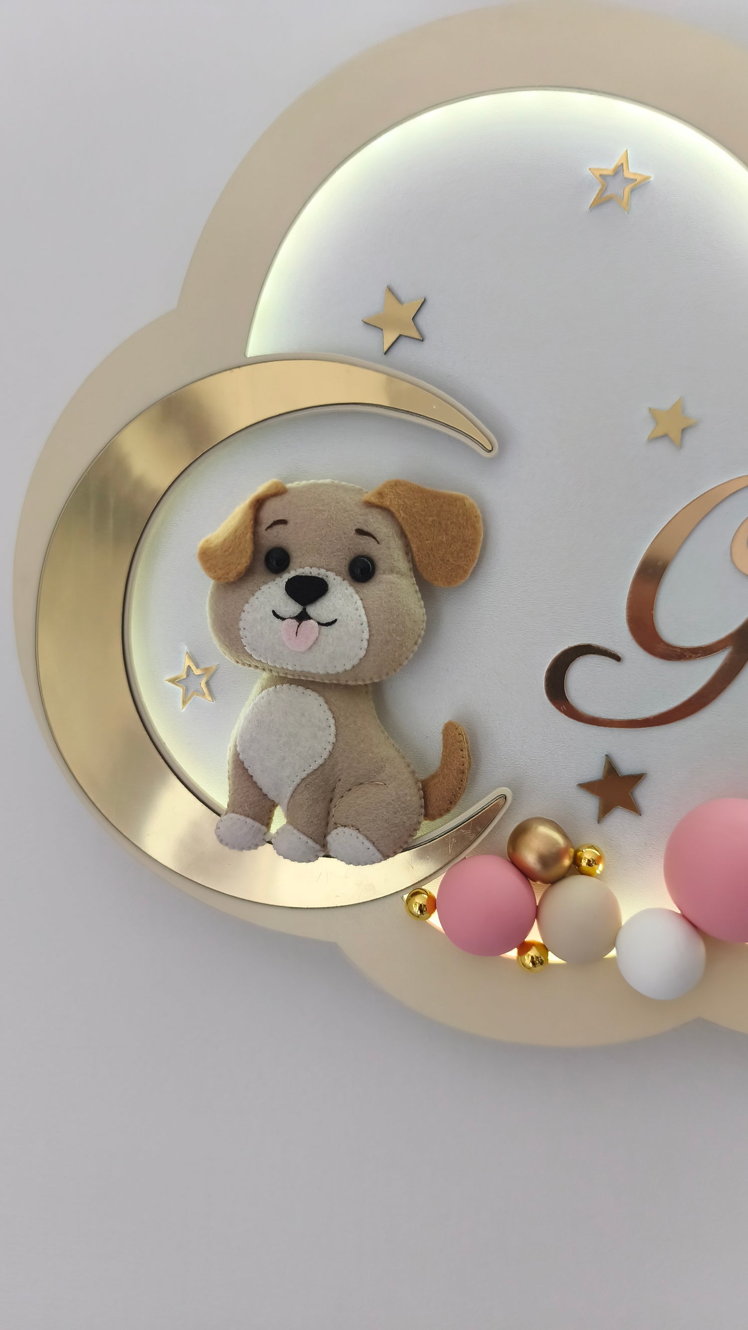 Dettaglio cagnolino in feltro su luna dorata, luce notturna nuvola panna cameretta