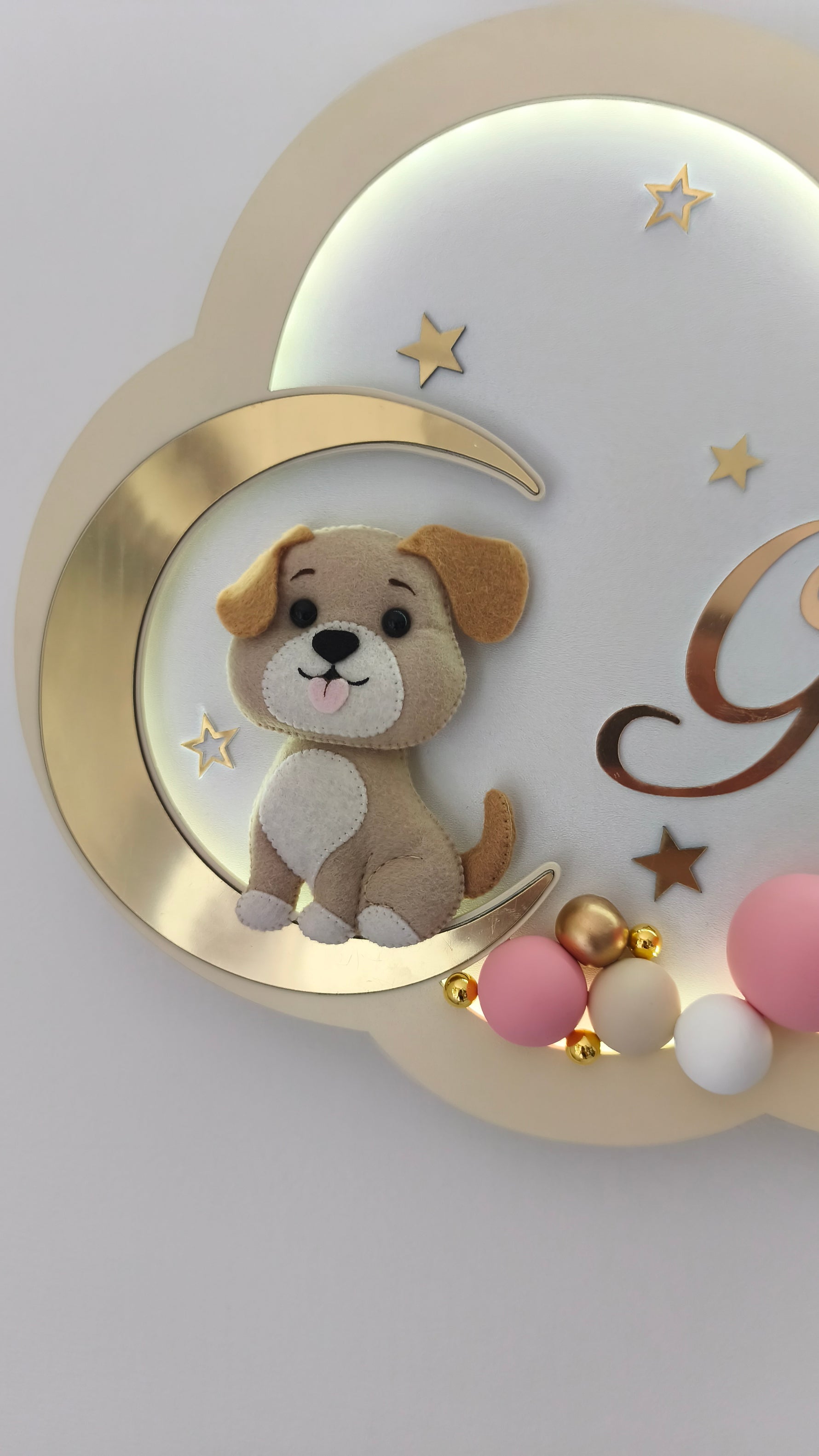 Dettaglio cagnolino in feltro su luna dorata, luce notturna nuvola panna cameretta