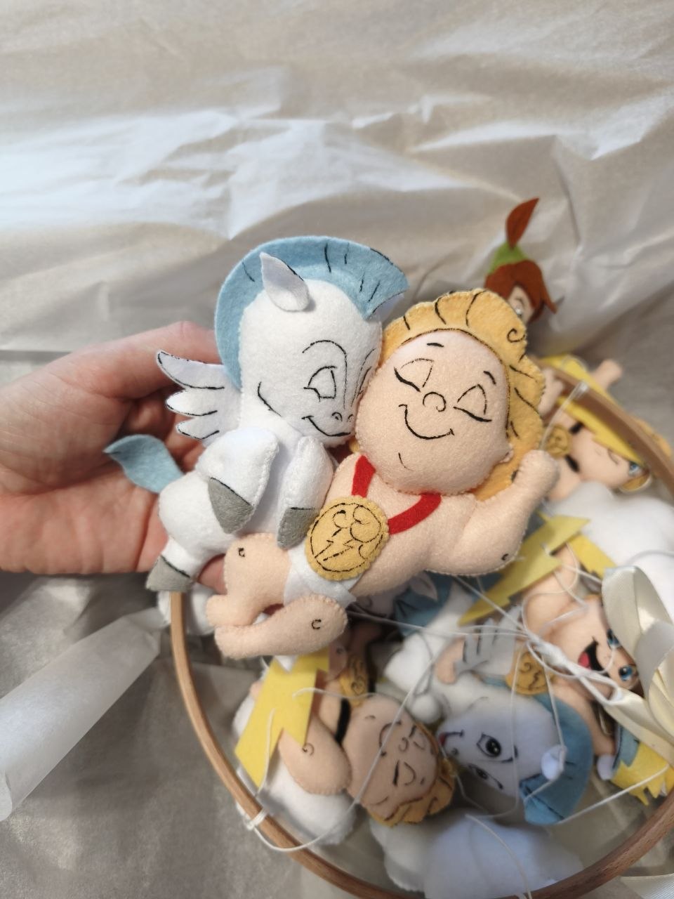Piccolo Hercules con medaglia d'oro e Pegaso in feltro fatti a mano sopra la scatola regalo della giostrina