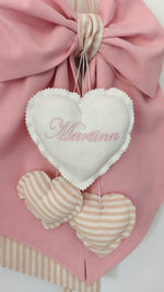 Dettaglio cuore ricamato con nome bambina su fiocco nascita rosa, cuoricini a righe beige