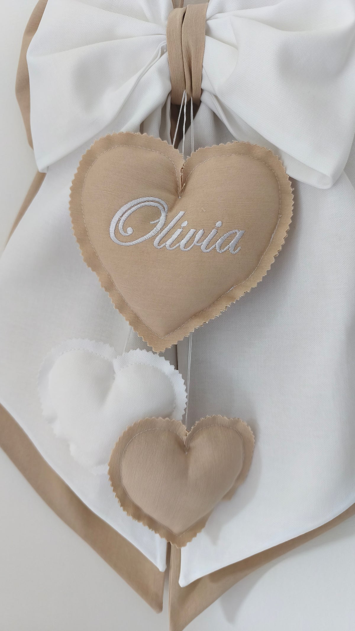 Dettaglio cuore ricamato Olivia con cuoricini a cascata, fiocco nascita tortora