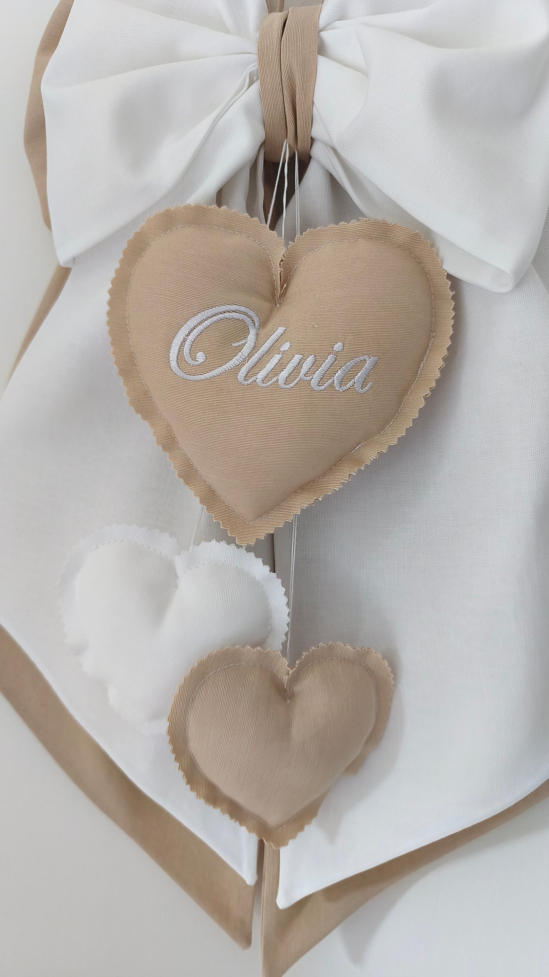 Dettaglio cuore ricamato Olivia con cuoricini a cascata, fiocco nascita tortora
