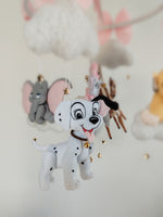 Dettaglio giostrina feltro con cucciolo dalmata bianco e nero e Dumbo grigio appesi a nuvole soffici.