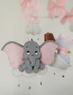 Dettaglio giostrina feltro con elefantino Dumbo grigio su nuvola bianca, grandi orecchie rosa e stelline