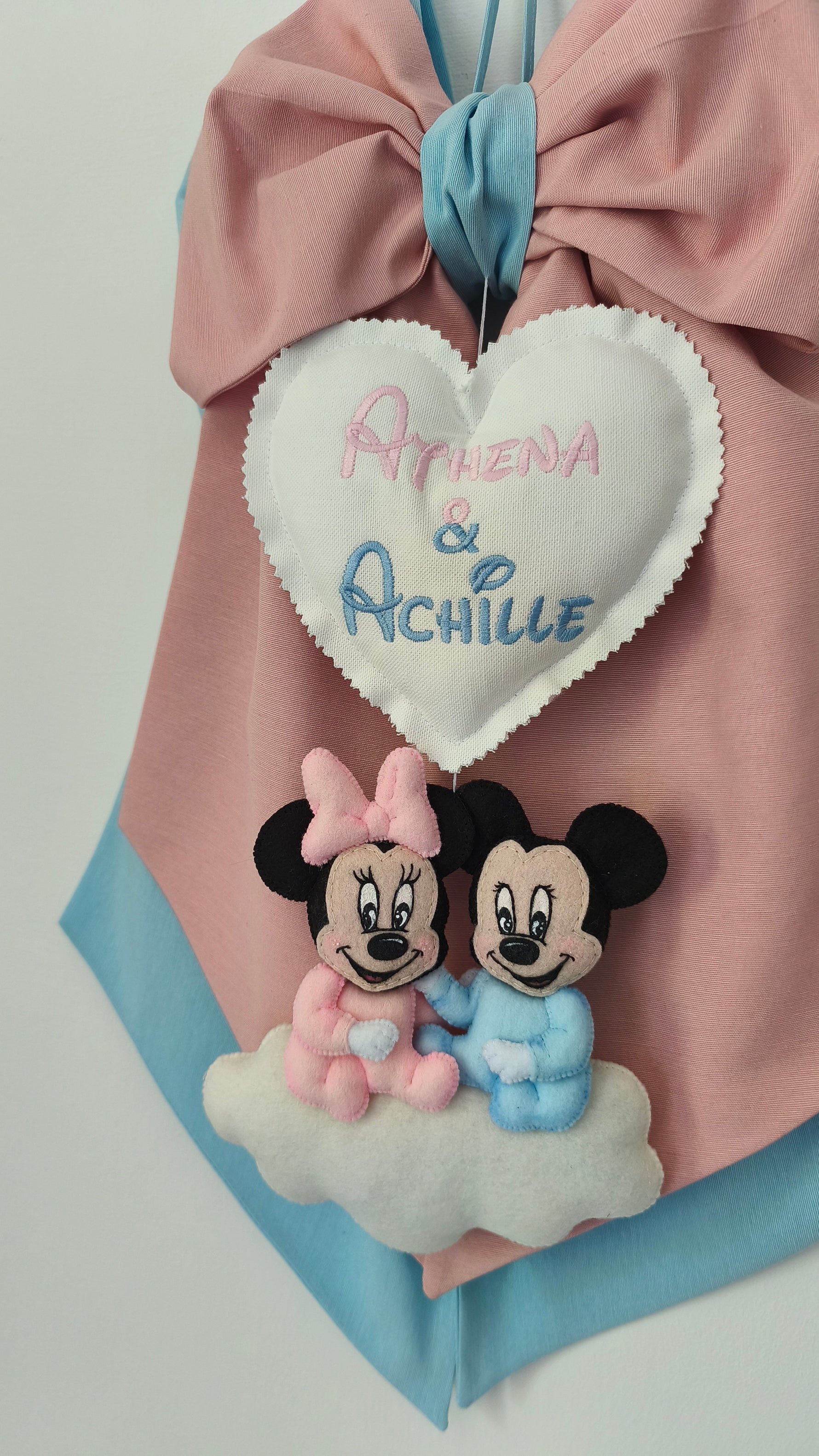 Dettaglio fiocco nascita gemelli con cuore ricamato due nomi in rosa e azzurro, coppia topolini feltro su nuvola, artigianale
