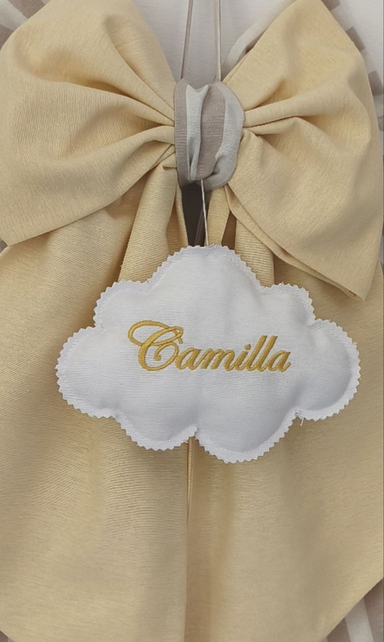 Dettaglio fiocco nascita giallo tenue con nuvola bianca in tessuto ricamata in filo dorato personalizzabile.