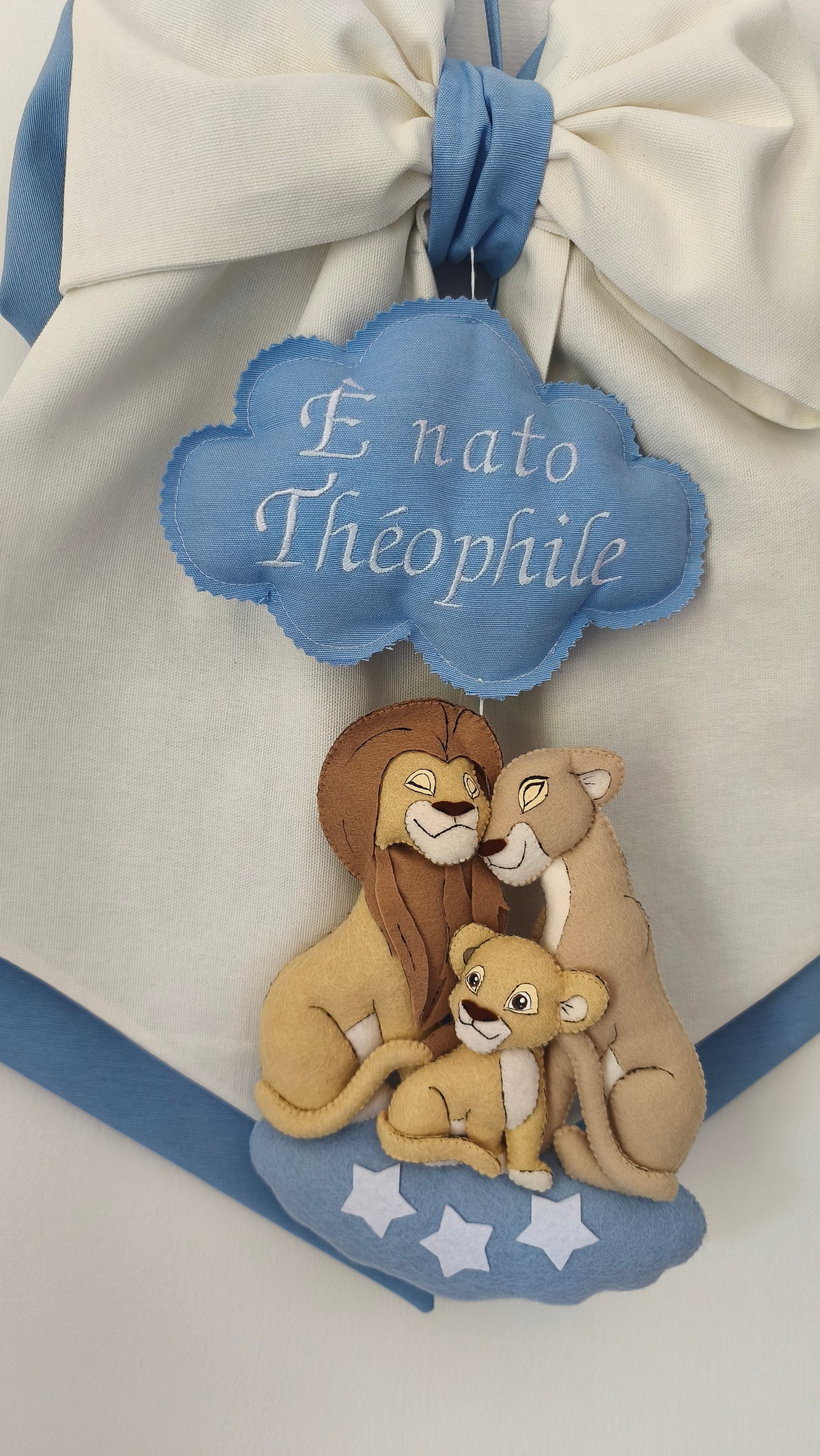 Dettaglio artigianale di un fiocco nascita personalizzato a tema Re Leone Disney con famiglia di leoni e stelle bianche.