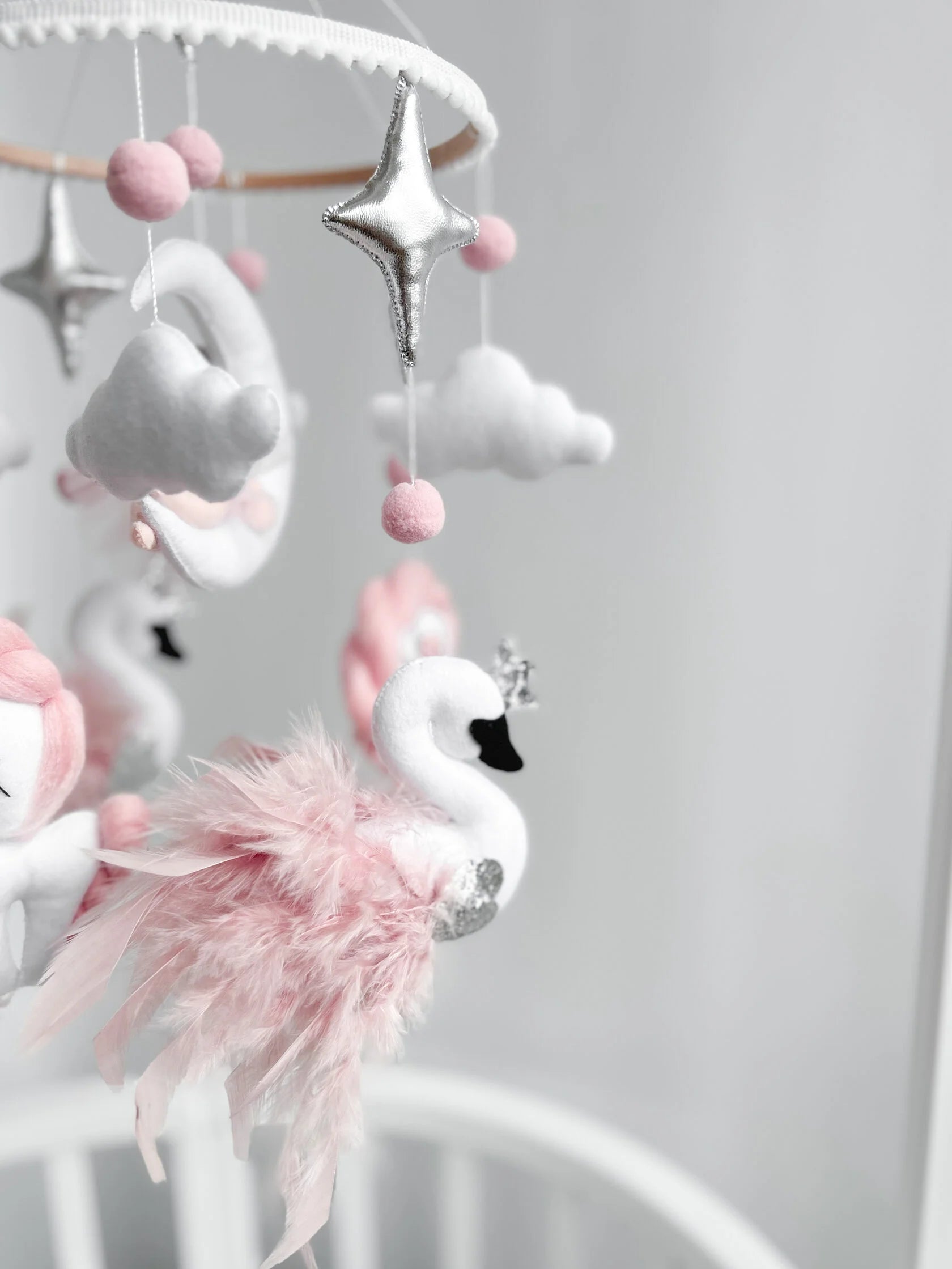 Dettaglio giostrina musicale culla cigno bianco con piume rosa e stelle argento mobile neonato handmade