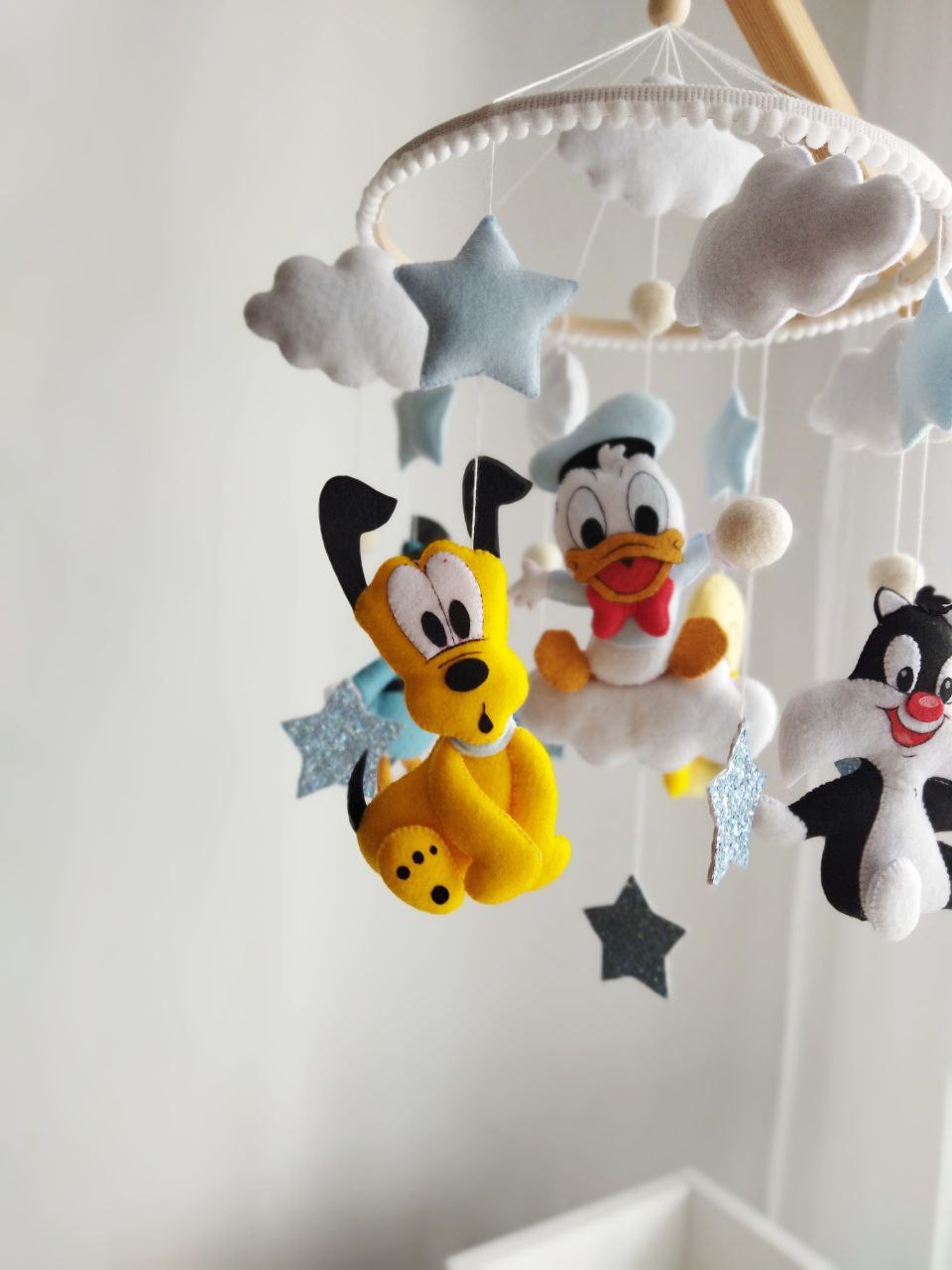 Giostrina musicale culla personalizzata Disney Pluto Paperino e Silvestro, feltro cucito a mano, stelle glitterate e nuvole per cameretta neonato.