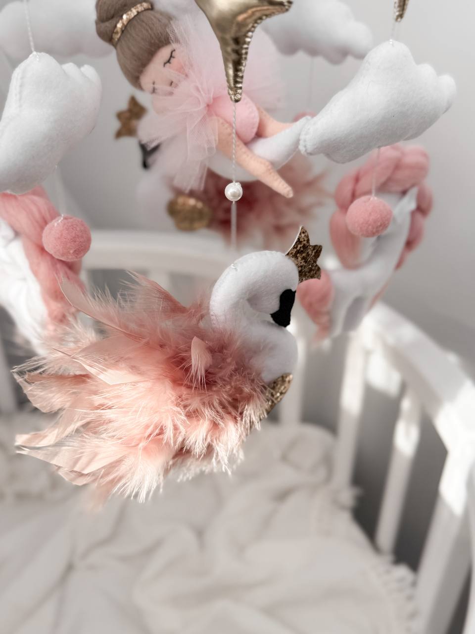 Dettaglio giostrina culla feltro cigno bianco piume rosa cipria ballerina tulle oro stelle nuvole neonata