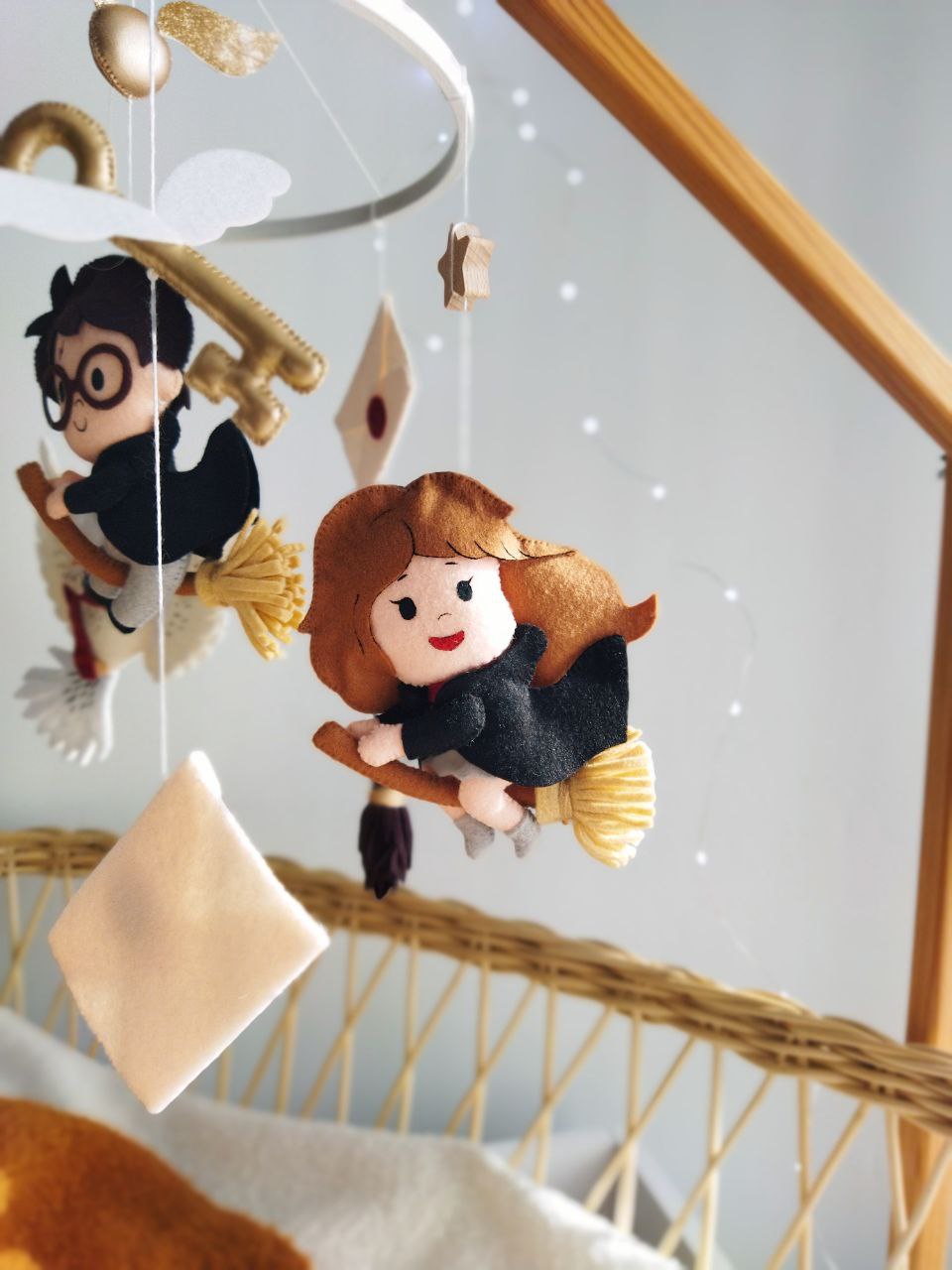 Giostrina culla Harry Potter dettaglio personaggio Hermione sulla scopa in feltro, decorazione lettino neonata.