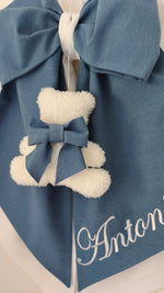 Dettaglio fiocco nascita azzurro con orsetto bouclé bianco e fiocchetto azzurro, nome ricamato in rilievo