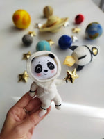 Dettaglio panda astronauta in feltro cucito a mano con stella dorata, pianeti sullo sfondo per giostrina spazio neonato