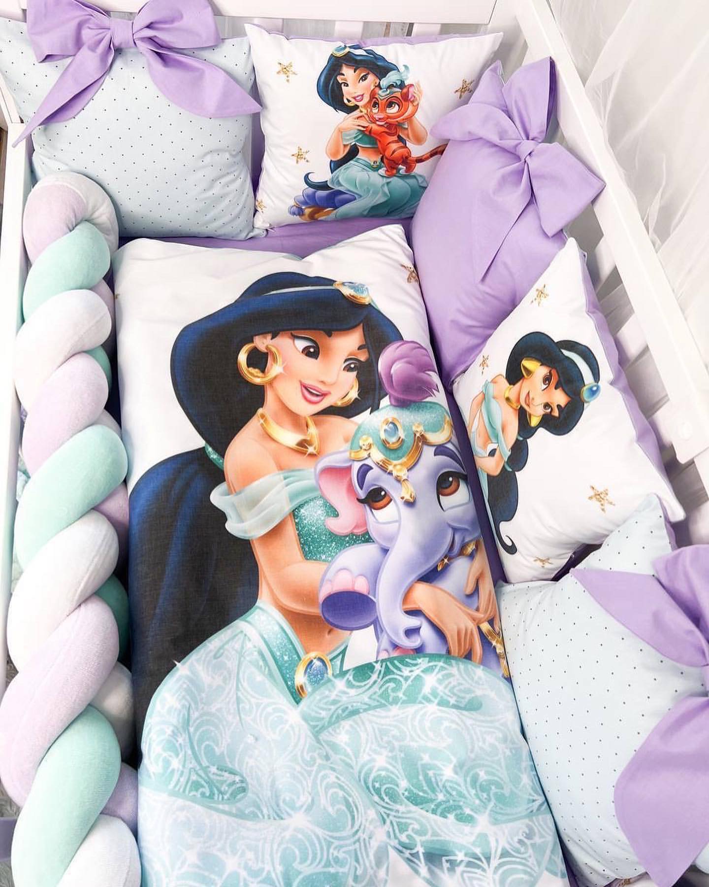 Dettaglio cuscini paracolpi sfoderabili Jasmine per lettino neonato con grandi fiocchi lilla e grafiche Disney