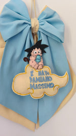 Primo piano del personaggio Goku neonato ricamato a mano su fiocco nascita azzurro e beige