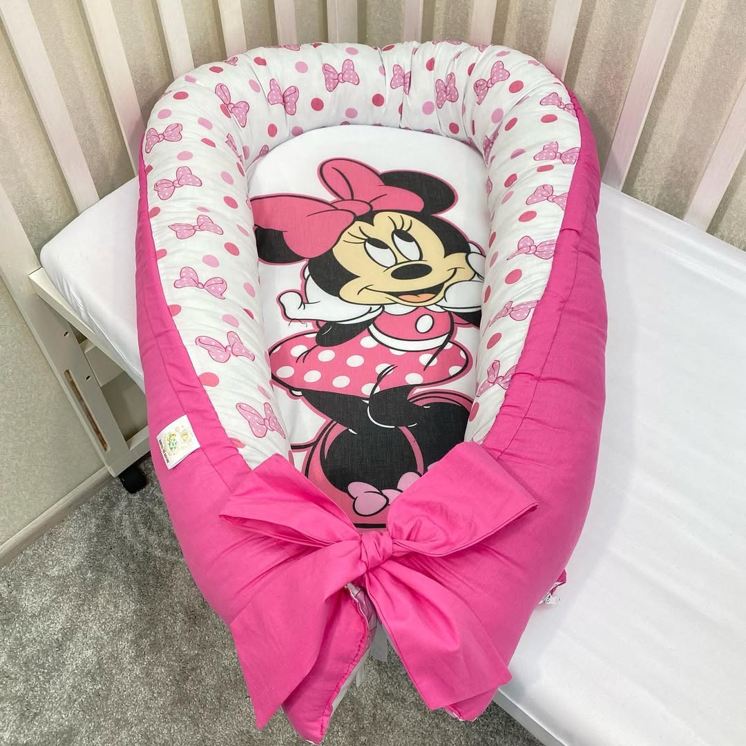 Riduttore lettino Minnie Disney rosa fragola, culla nido bambina con fiocchi e pallini fucsia.