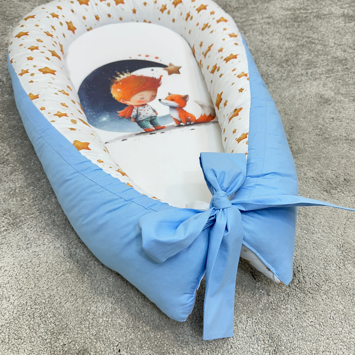 Riduttore nido neonato Piccolo Principe, dettaglio baby nest azzurro con grande fiocco e volpe.